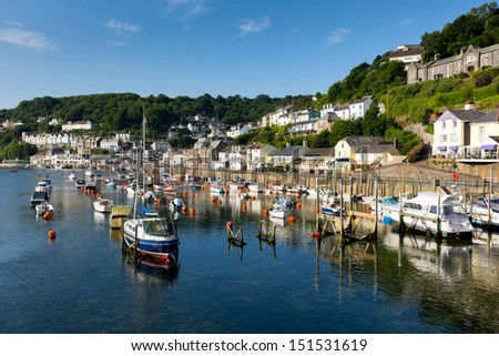 Boats Looe harbour and river Cornwall England, with blue sea on a sunny summer day and town on the hillside Royalty-Free Stock Photo #151531619
