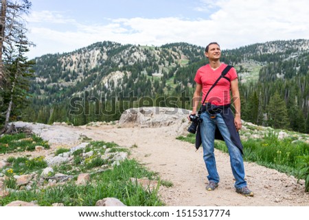 Albion Basin, Utah summer with rocky trail view in Wasatch mountains with man tourist standing on road to Cecret Lake and wildflowers