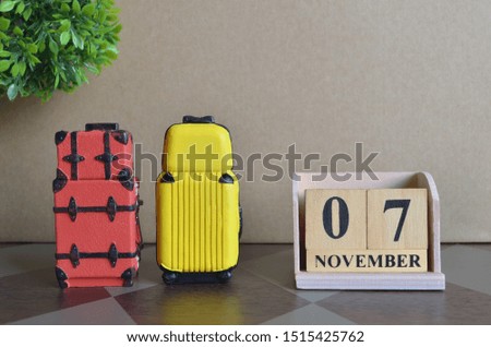 Appointment Date 7, November, Holiday, Travel cover with number cube and luggage.