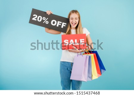 happy screaming blonde girl with 20% off sale sign and colorful shopping bags isolated over blue