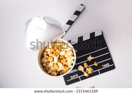 Movie Clapper Board in popcorn isolated on white