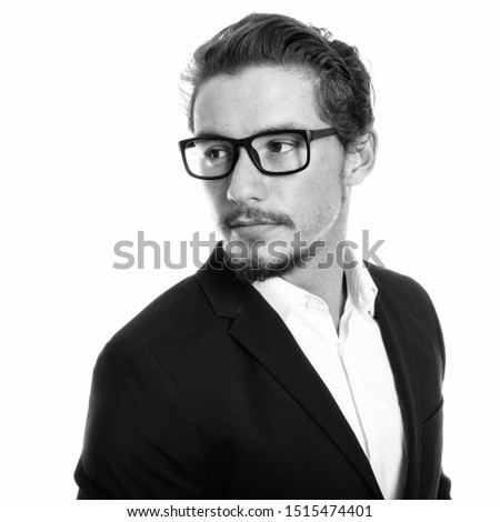 Close up of young handsome businessman thinking while looking back with eyeglasses isolated against white background