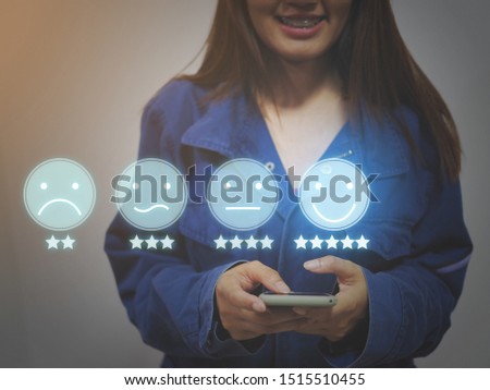 Customer experience concept, happy business women holding the smartphone with a checked box on excellent smiley face and rating for a satisfaction survey.