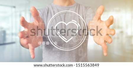 View of a Businessman holding a heart icon surrounded by data