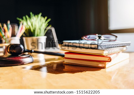 Colorful notebooks with glasses and hammer of a judge on wooden table.law firm concept