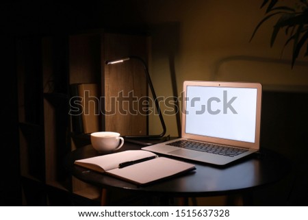 Modern workplace with laptop in evening Royalty-Free Stock Photo #1515637328