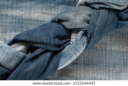 many jeans of different shades of blue lie woven oblique layers nearby