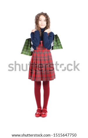 Child with a green packaging checkered texture isolated on white background. Girl likes shopping on sale season. Holiday present, shopping.Happy girl with long curly hair. High resolution photo. Full 