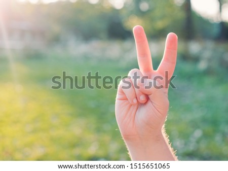 Mans Hand Show Victory Sign. Hand with two fingers up in the peace symbol. Outdoors, lifestyle concept, Copyspace