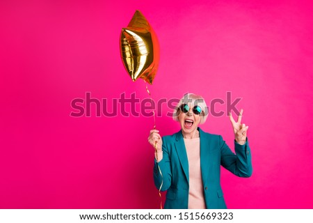 Portrait of her she nice-looking attractive crazy overjoyed cheerful cheery gray-haired lady holding balloon showing v-sign isolated on bright vivid shine vibrant pink fuchsia color background