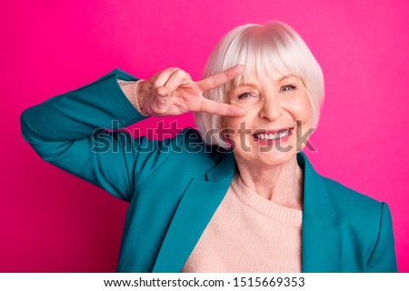 Close-up portrait of her she nice attractive cheerful cheery funky gray-haired lady wearing blue jacket showing v-sign near eye isolated on bright vivid shine vibrant pink fuchsia color background