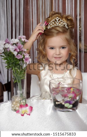 Little girl in white dress with diadem