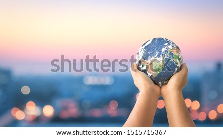 Human rights concept:  Human hands holding earth global over blurred city night background. Elements of this image furnished by NASA