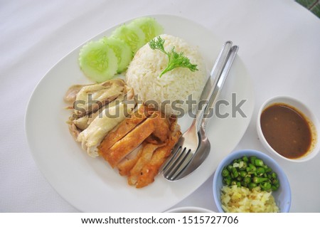 oily rice with streamed chicken and spicy chicken steak with soup and sauce On the plate