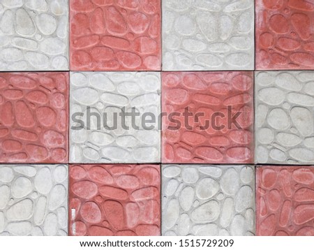 concrete coating of gray and red colors. Sidewalk of gray and pink pavers close-up. Texture, background from curly gray-orange stone. Top view on the sidewalk