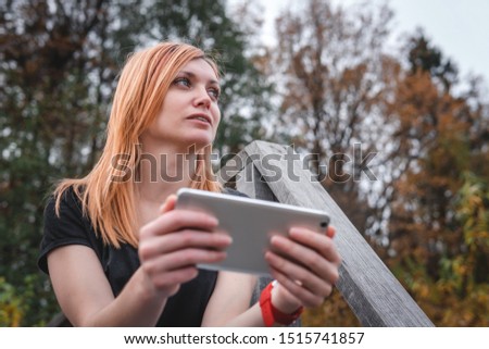 Woman using a smartphone. outdoor hiking travel. forest background. autumn day. communication, internet and mobile network. copy space