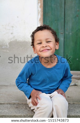 little boy smiling and sitting down stock photo