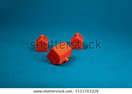 three red houses including one upside down on a blue background