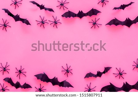Stylish Halloween design. Bats and spiders on pink background top view space for text frame