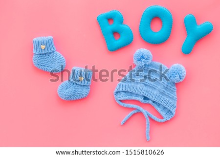 Children's birthday concept. Word boy near booties on pink background top view
