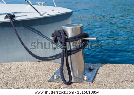 mooring knotted on a bollard against the background of a yacht and the sea