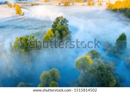 Autumn tranquil landscape from above. Meadow covered with frost at sunrise. Autumn background. Fall sunrise. Aerial view