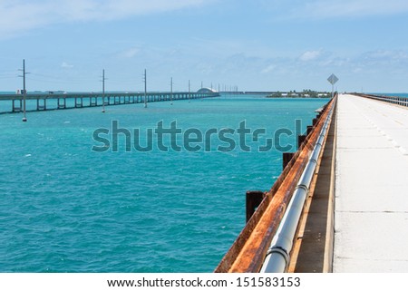 This image shows the original seven mile bridge and the current highway. Pigeon Key is in the background.