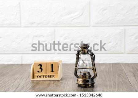 vintage lantern with wooden calender that show 31 october on white wall brick background, halloween concept