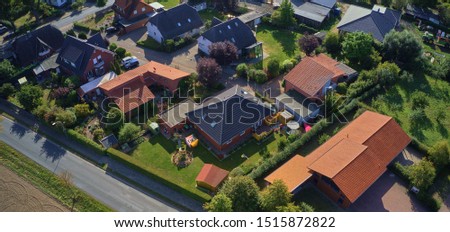 Aerial view of the roofs of a single-family house settlement on the edge of the country road of a German suburb