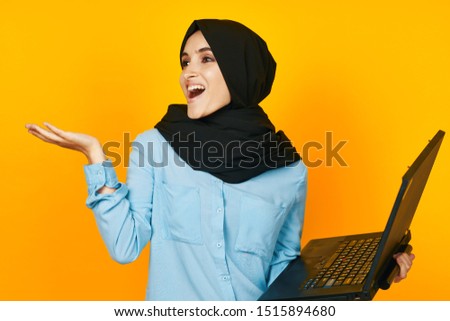 beautiful woman with a black laptop in a yellow scarf
