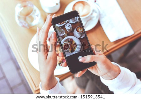 A girl takes photos of delicious food on the phone. Photo for the blog. Lifestyle. Blogger.Selective focus.