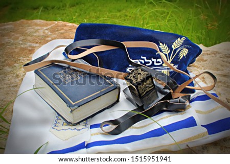 Jewish prayer set in Israel: Tanah, Tefillin and Tallit. Translation from hebrew: Torah Neviim Ketuvim, Talit and put on the head Royalty-Free Stock Photo #1515951941
