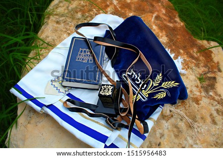 Tanah (Hebrew Bible), Tefillin (box with verses from the Torah) and Talit (prayer shawl). Translation from hebrew: Torah Neviim Ketuvim, Talit and put on the head Royalty-Free Stock Photo #1515956483