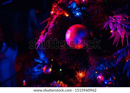 beautifully decorated with balls and Christmas toys festive Christmas tree at night with colorful bright light