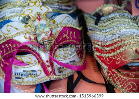 Group of carnival masks during the Mardi Gras fashion shows. Isolated colored on a counter for sale. Masks that cover the face on the eyes.