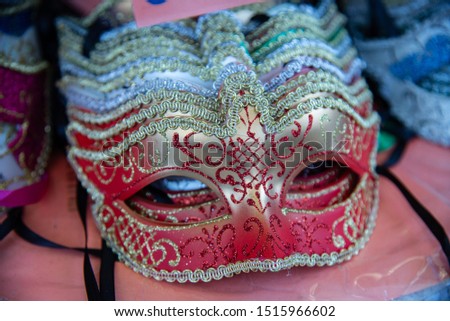 Group of carnival masks during the Mardi Gras fashion shows. Isolated colored on a counter for sale. Masks that cover the face on the eyes.