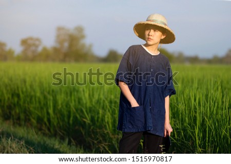 Asian young farmer and rice field background 