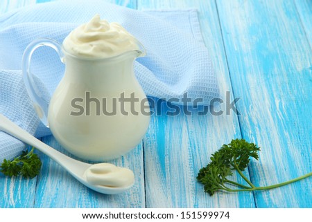 Sour cream in pitcher on table close-up