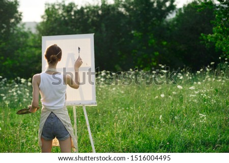 woman on white canvas paints a picture