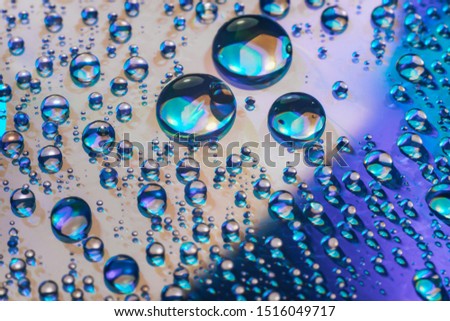 Close up colored water drops on a cd disk background.