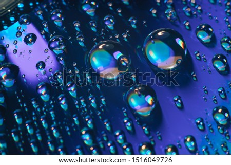 Close up colored water drops on a cd disk background.