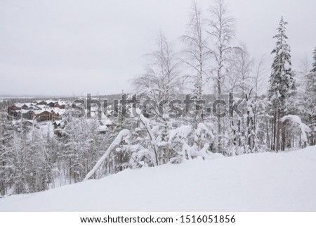 Panorama of a snowy ski village in northern Finland with a cloudy sky.