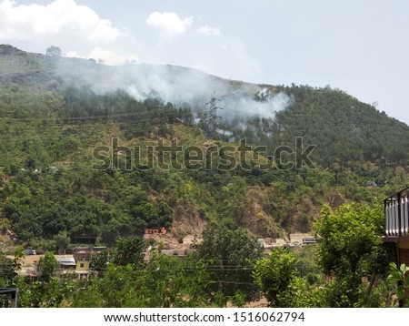 it is a picture of hill with smoke of fire.