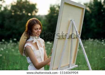 stylish woman in a sundress draws in the forest