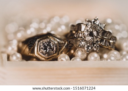 Pair of gold wedding rings with diamonds on pearl background with bokeh,Vintage picture style