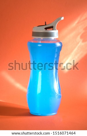 Isotonic drink. Cold blue detox cocktail in a sports bottle. Beverage concept for sports and fitness. Maintaining the body's water balance during training. Copy space