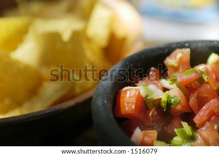 A bowl of fresh salsa in front of a bowl of chips in a simple mexican restaurant in shallow DOF Royalty-Free Stock Photo #1516079