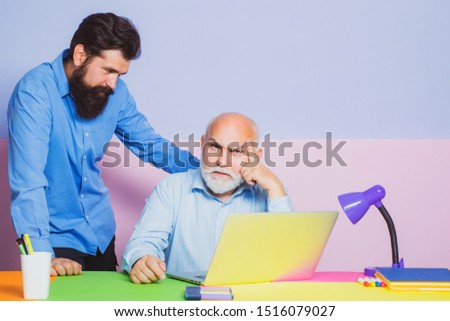 Couple of two office workers working at laptop screen. Office workers. Two business colleagues at meeting in modern color office interior