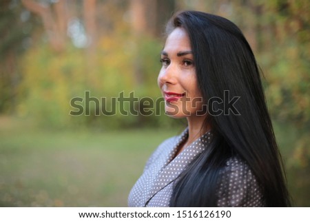 Young woman and black hair in autumn in the park