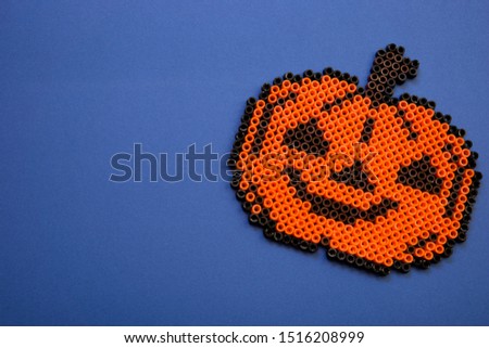 Image of a toy pumpkin. Hallowen party decoration. Blue background Royalty-Free Stock Photo #1516208999